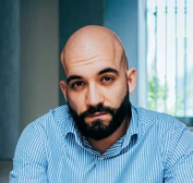 man in blue and white checkered dress shirt and black denim jeans sitting on concrete bench