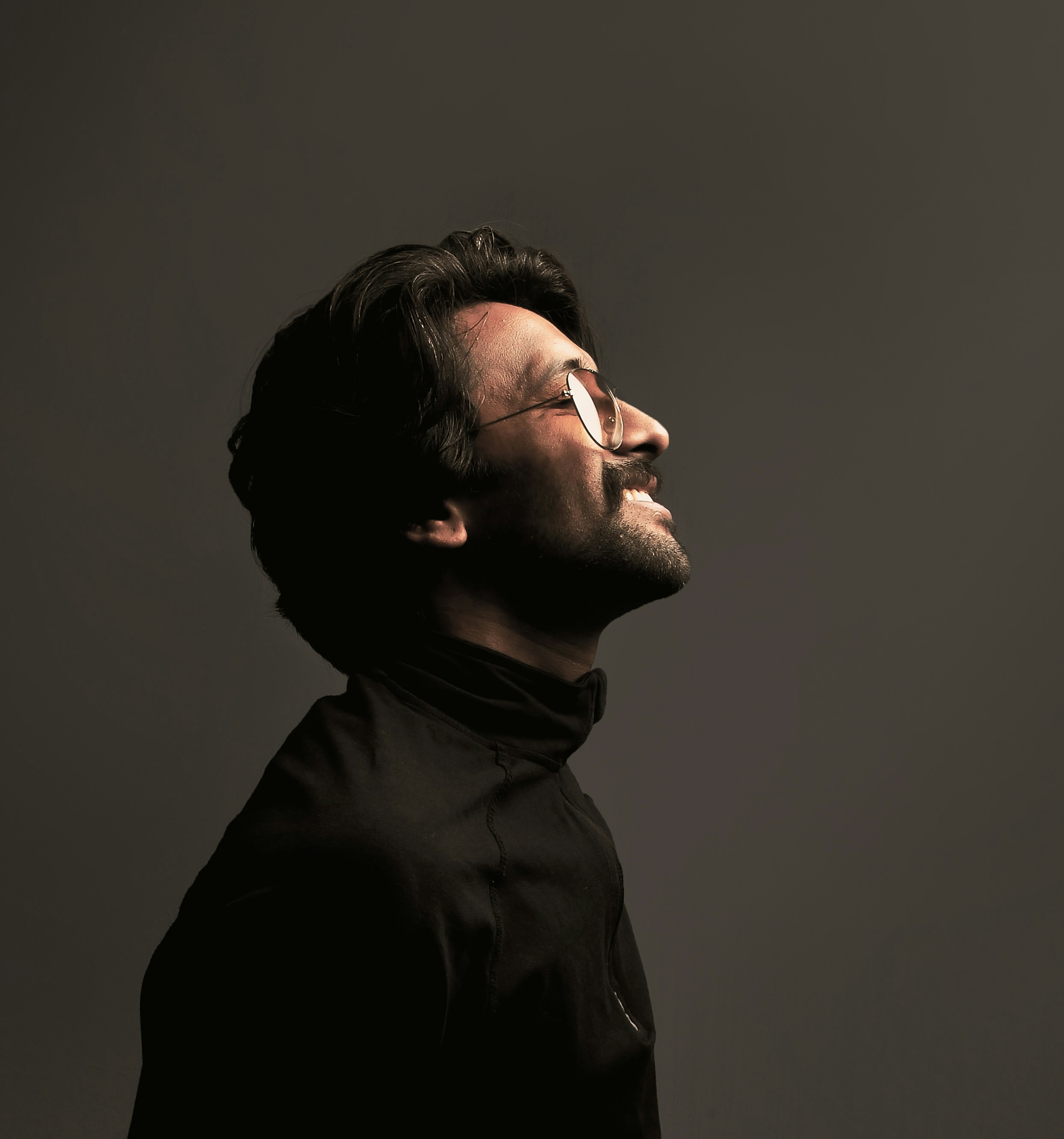 a man with glasses looking up into the sky